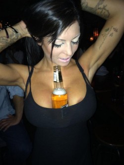 Sugar Bentley holding beer bottle between her boobs